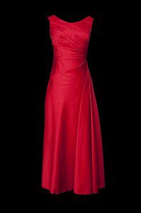 Długa czerwona suknia wieczorowa z zakładkami, dekoltem w łódkę i odkrytymi plecami wyciętymi w szpic.