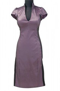 Krótka sukienka biznesowa w kolorze fioletowym z czarnymi pasami po boku, które wyszczuplają sylwetkę. Delikatny dekolt w literę V.