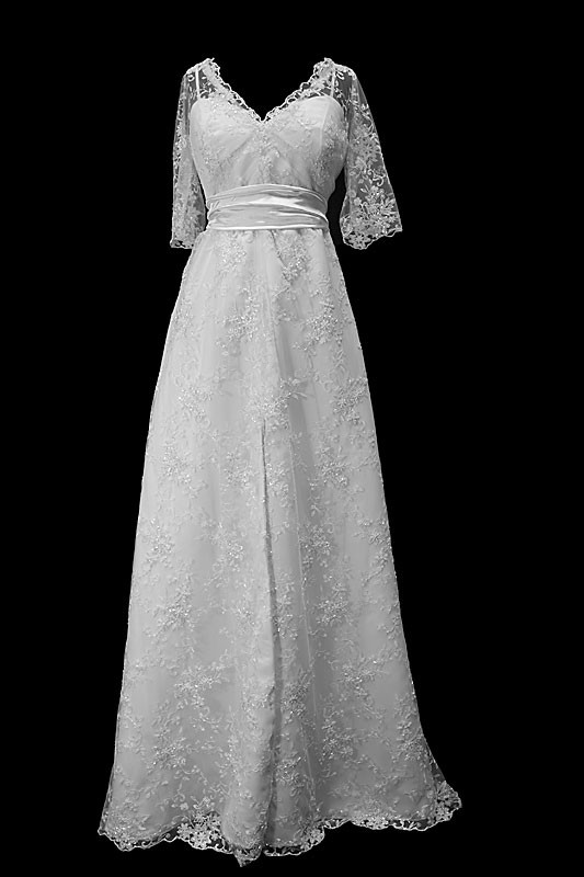 Klasyczna koronkowa suknia ślubna z rękawkami, dekoltem w serduszko oraz paskiem w zakładki.
