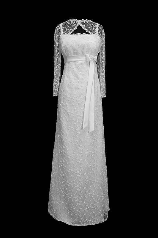 Długa suknia ślubna z odcinanym gorsetem na ramiączkach. Sukienka posiada koronkowe rękawki w stylu vintage oraz pasek z kokardą.
