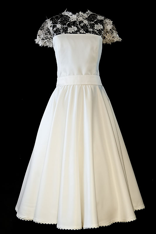 Krótka suknia ślubna odcinana w pasie z prostym dekoltem z koronkowymi plecami i guziczkami.
