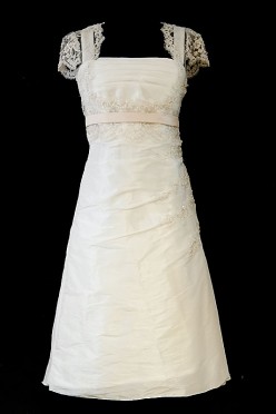 Krótka koronkowa sukienka ślubna o fasonie w literę A, z cienkim różowym paskiem i krótkimi rękawkami.