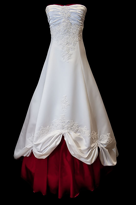 Długa suknia ślubna z koronkowymi zdobieniami i marszczeniami na gorsecie z prostym dekoltem. Sukienka z zakrytymi plecami i wiązaniami gorsetowymi.
