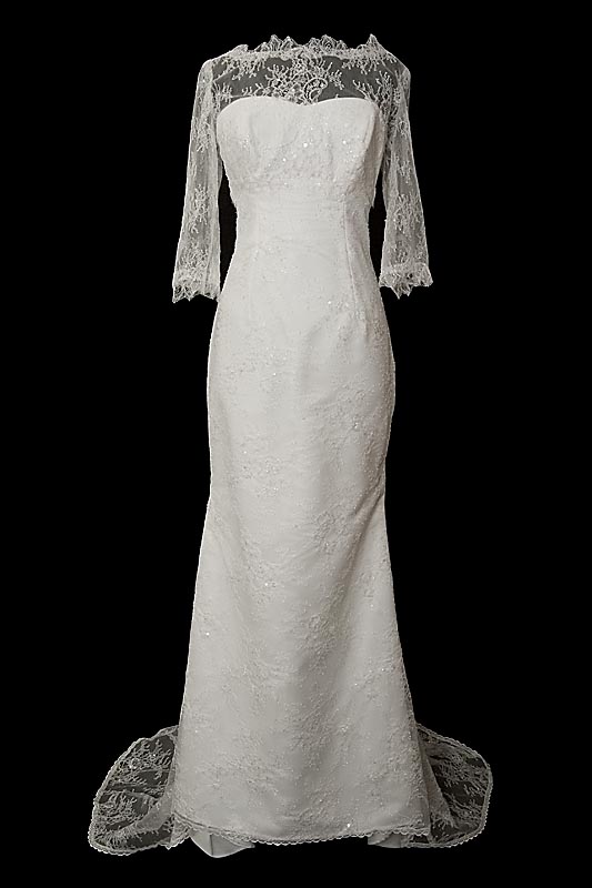 Długa koronkowa suknia ślubna Reiko z dekoltem w serduszko, rękawkami, gołymi koronkowymi plecami oraz upinanym trenem.