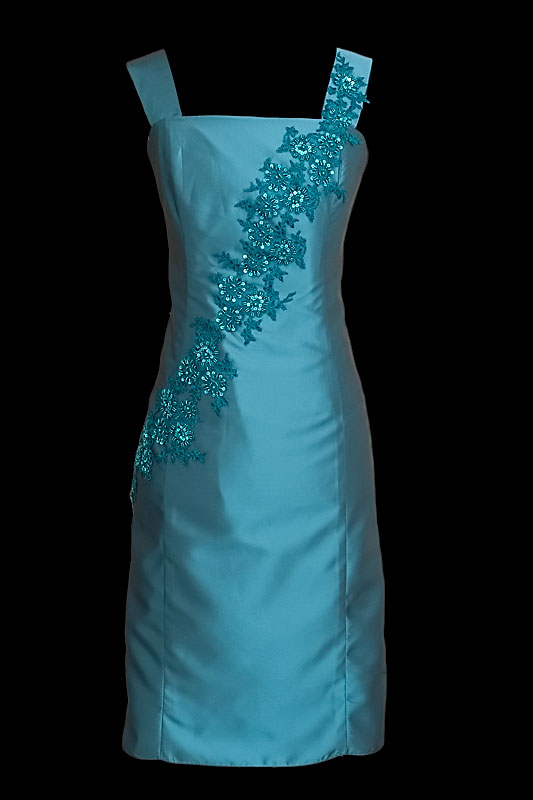 Krótka elegancka sukienka koktajlowa / wizytowa w kolorze niebieskim z poprzecznie naszywanym niebieskim haftem, z dekoltem prostym oraz szerokimi ramiączkami.