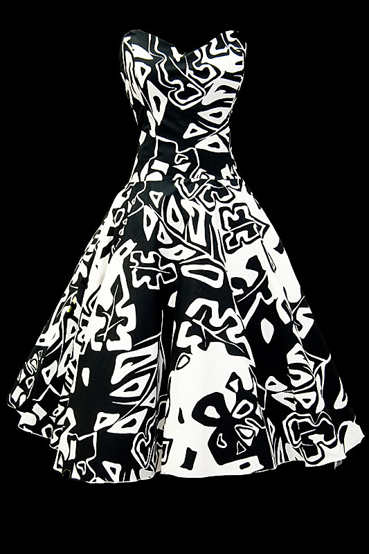 Czarno-biała sukienka koktajlowa z nieregularne wzory na gorsecie z dekoltem w serduszko.
