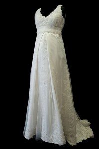 Suknia ślubna ciążowa retro z oryginalną spódnicą, koronkowymi dodatkami, portfelowym dekoltem w szpic oraz upinanym trenem.