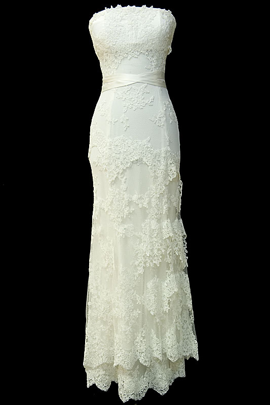 Długa koronkowa suknia ślubna w stylu retro. Sukienka z koronkowym gorsetem z zakrytymi plecami i prostym dekoltem.