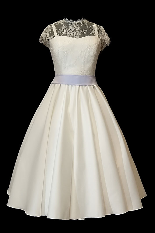 Krótka koronkowa sukienka na ślub z dekoltem w serduszko na ramiączkach, spódnicą z koła szerokim lawendowym paskiem.