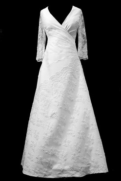 Długa suknia ślubna z portfelowym dekoltem w szpic, koronkowymi rękawkami i haftami naszywanymi na spódnicę.
