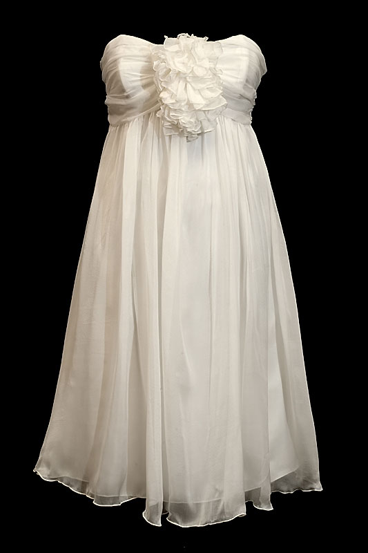 Krótka zwiewna sukienka ślubna z dekoltem w serduszko, dużym kwiatem na biuście i pięknymi marszczeniami.