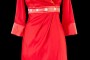 Krótka czerwona suknia wieczorowa z szerokim kołnierzem , długim rękawem i wąskim paskiem zdobionym kamieniami.