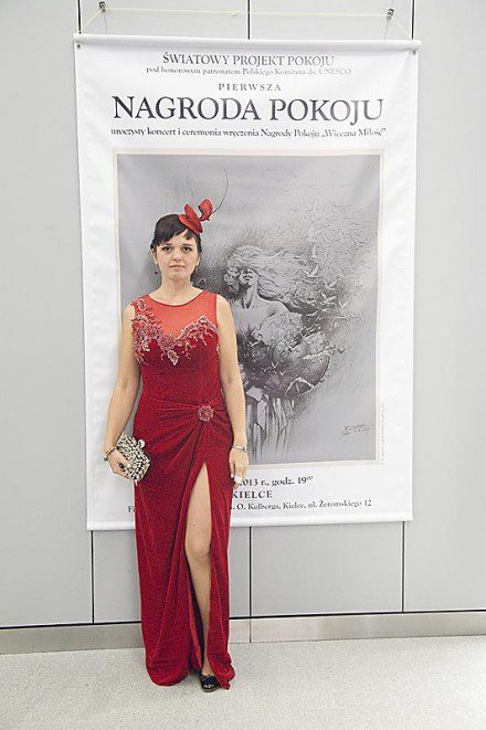 Kama Ostaszewska w czerwonej sukni i fascynatorze podczas koncertu z okazji wręczenia pierwszej polskiej Nagrody Pokoju Wieczna Miłość.
